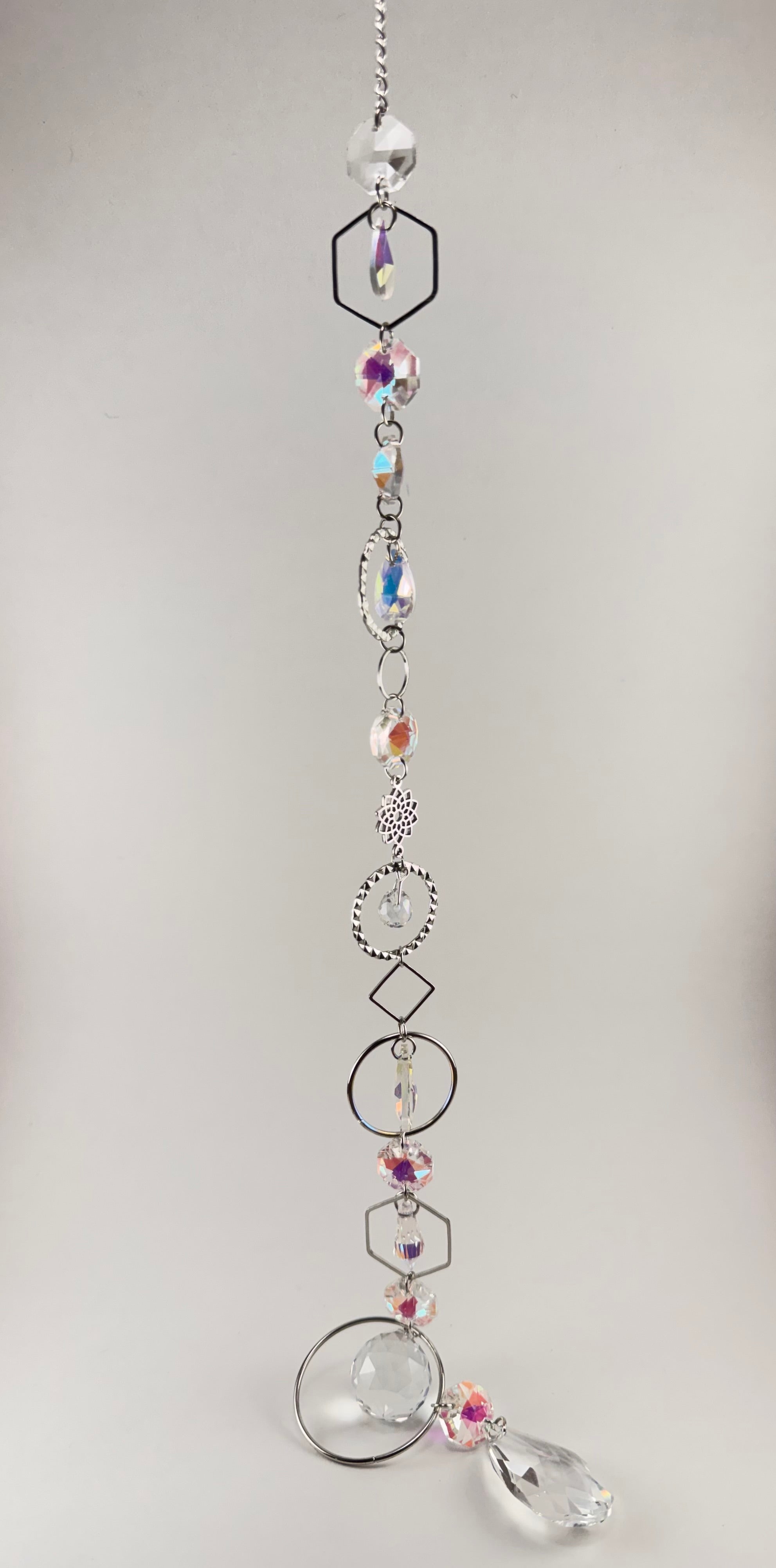 Iridescent white beaded sun catcher with Tree of Life charm, hexagon, oval, diamond, and circle silver frames, and clear teardrop pendant